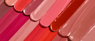 Muestra de tiras de esmalte en una variedad de tonos nude y rosa, dispuestas en diagonal.