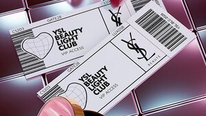 Productos de belleza YSL que incluyen una polvera acolchada, mascara de pestanas y dos labiales sobre fondo de azulejos rosas brillantes.