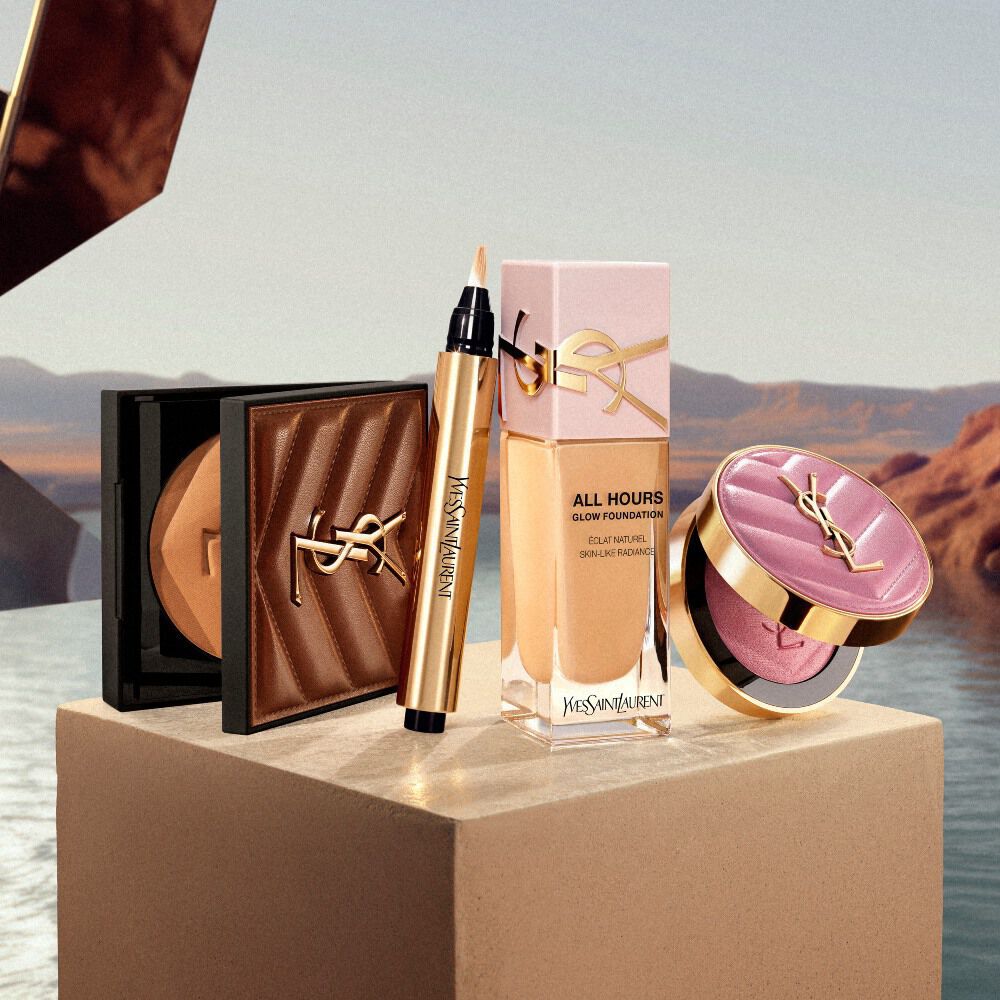 Esenciales de maquillaje YSL expuestos sobre un pedestal en un entorno inspirado en el desierto.