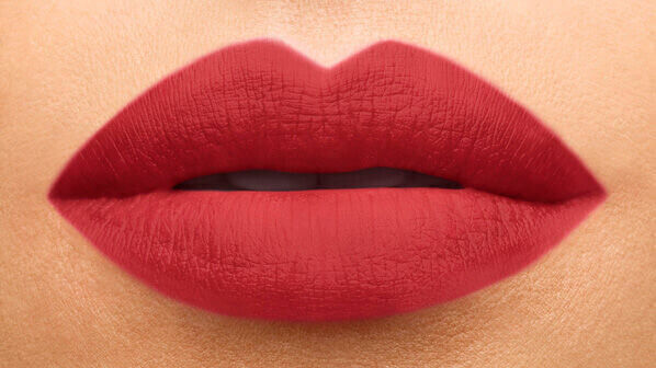 Close-up of a pair of well-defined lips painted in a rich red shade, showcasing smooth texture and a matte finish.