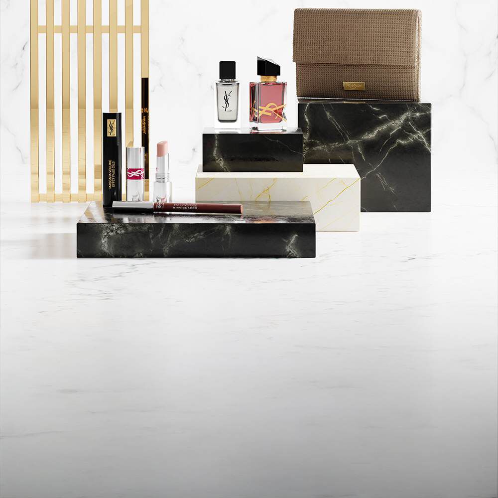 Productos de belleza YSL sobre pedestales de marmol de lujo.