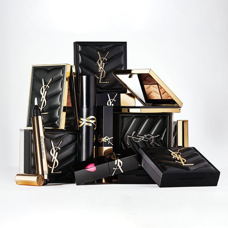 Productos de belleza YSL de lujo en envases negros y dorados.