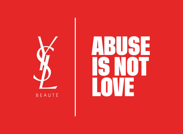 Logotipo de YSL Beaute en blanco y el mensaje "ABUSE IS NOT LOVE" en blanco, separados por una linea vertical, sobre un fondo rojo vibrante.