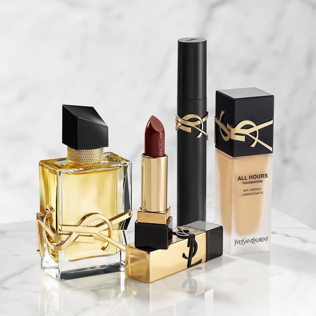 Productos de belleza YSL: perfume, pintalabios, mascara y base de maquillaje sobre marmol.