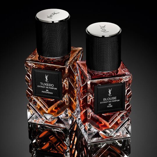 New Le Vestiaire des Parfums bottle on a black background with flowers behind it.