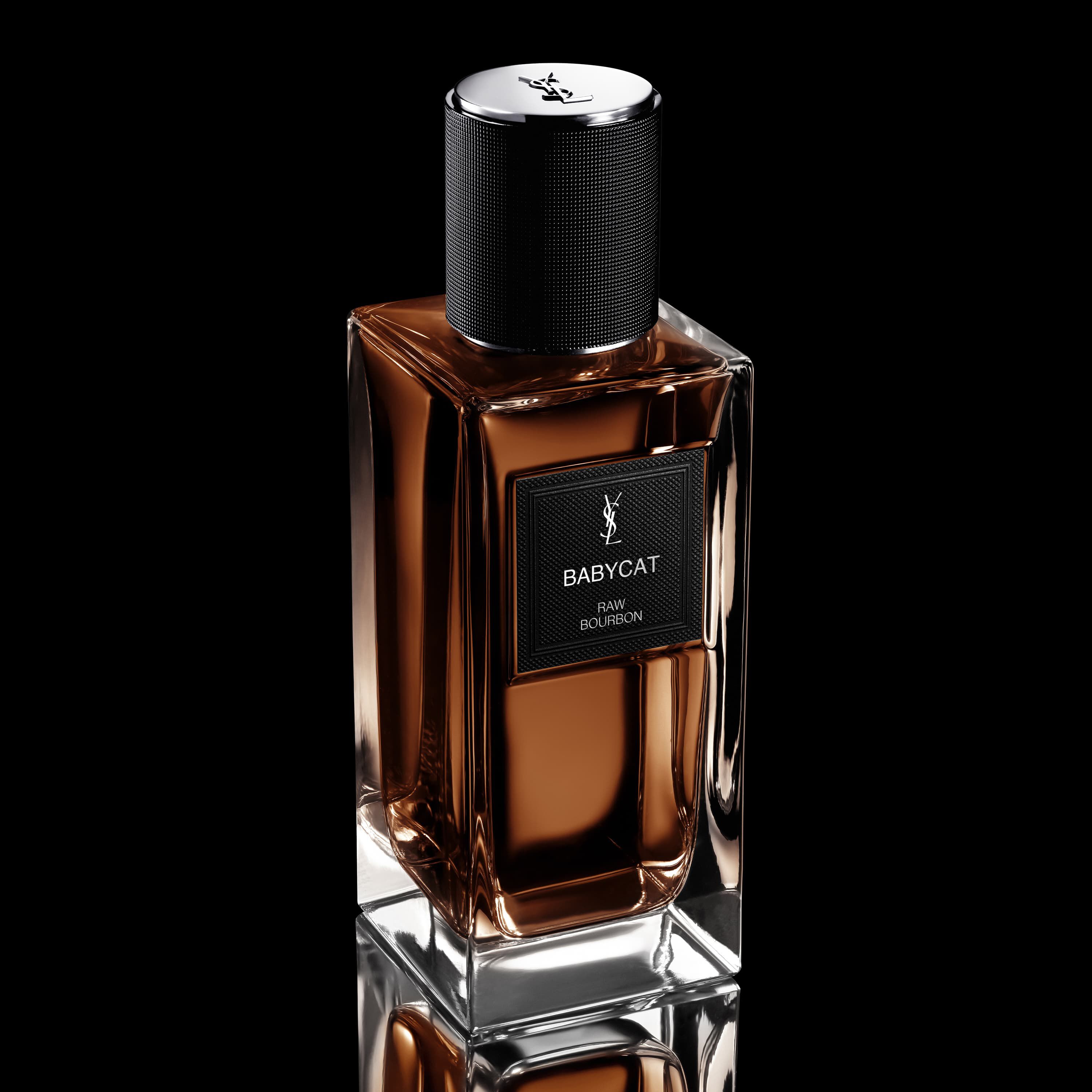 Frasco de perfume YSL Babycat Raw Bourbon con liquido marron, etiqueta negra y tapa negra texturizada.