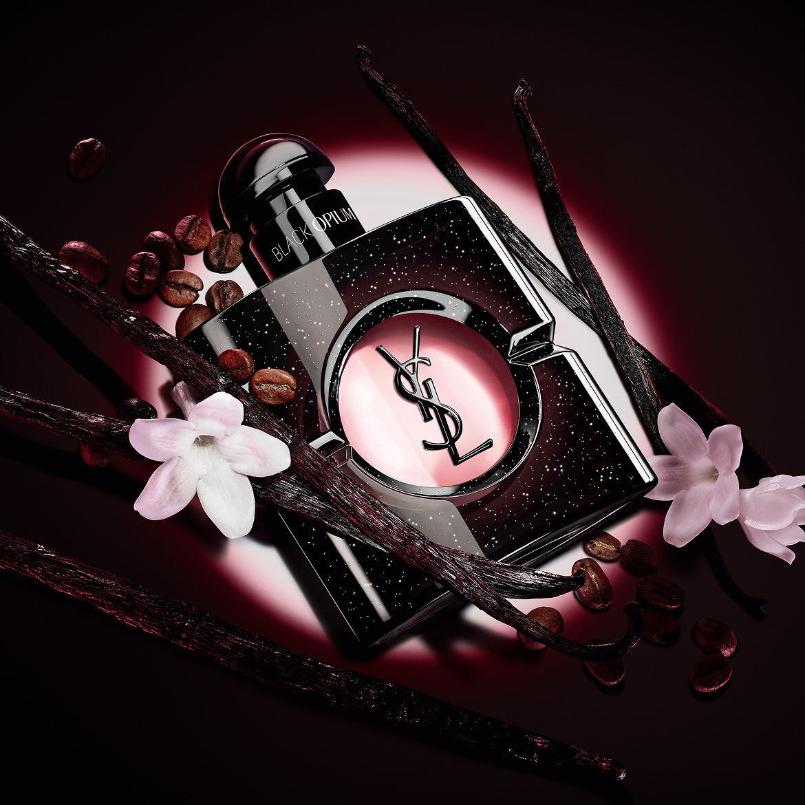 Frasco de Black Opium Eau de Parfum con flores de jazmin blanco, vainas de vainilla y granos de cafe tostado.