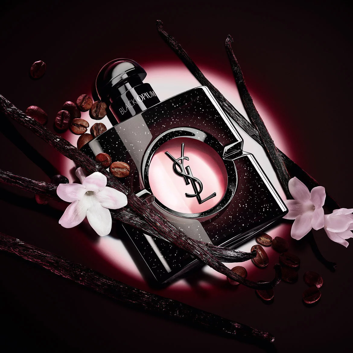 Frasco de Black Opium Eau de Parfum con flores de jazmin blanco, vainas de vainilla y granos de cafe tostado.