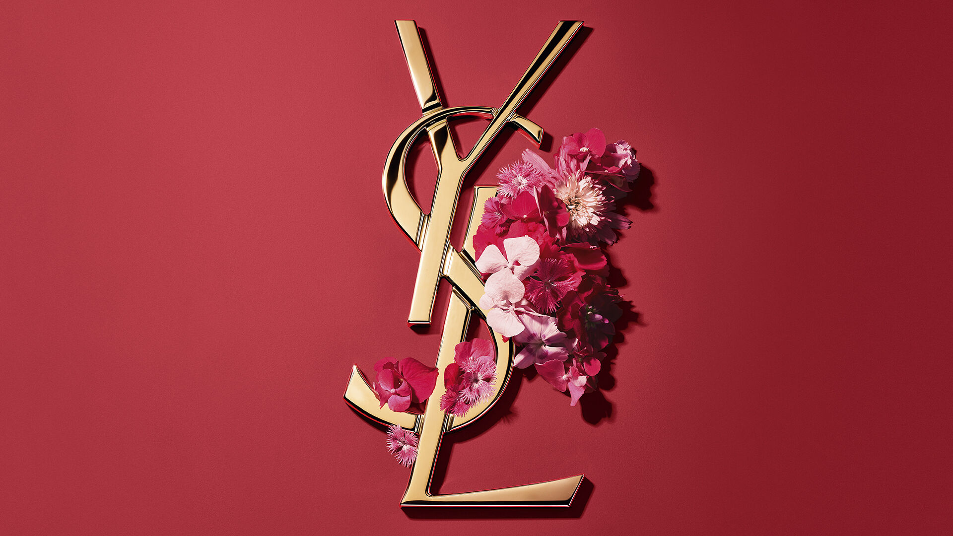 Caja de regalo YSL roja con flores rosas sobre fondo rojo.