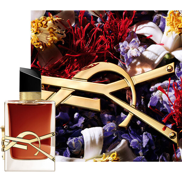 Frasco de LIBRE LE PARFUM acompanado de elementos florales rojos y el logo YSL dorado.