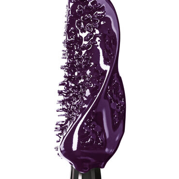 Primer plano extremo de un aplicador de mascara cubierto por una formula cremosa y brillante de color violeta oscuro.