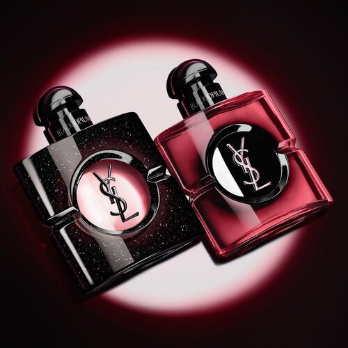 Dos frascos de perfume Black Opium de Yves Saint Laurent iluminados sobre fondo oscuro.