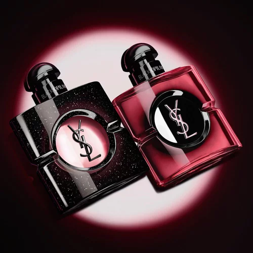 Dos frascos de perfume Black Opium de Yves Saint Laurent iluminados sobre fondo oscuro.