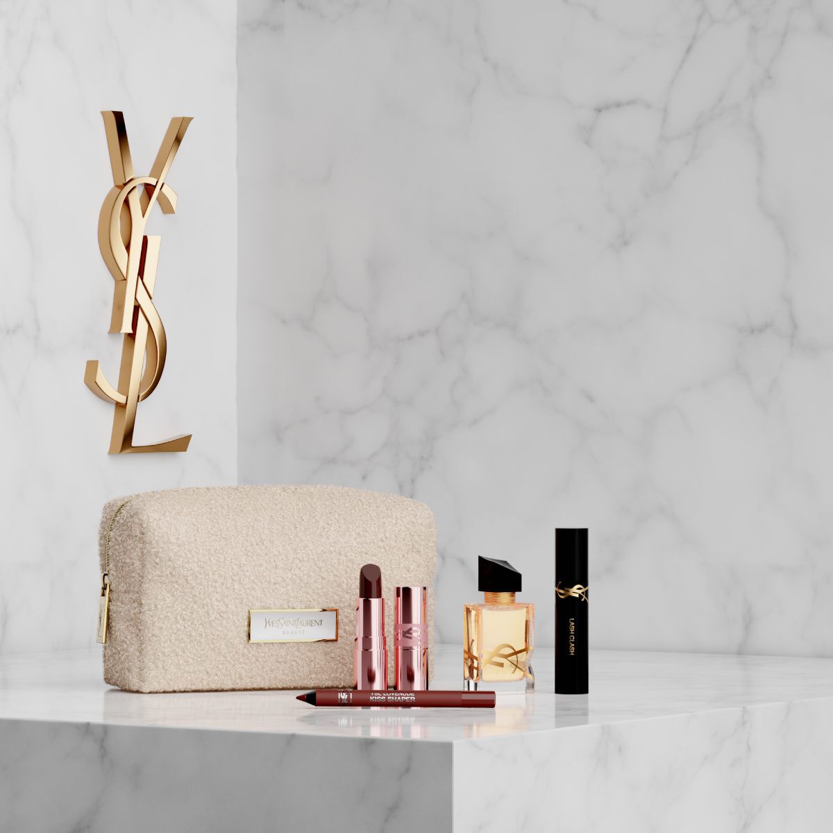 Neceser, perfume Libre y maquillaje YSL sobre fondo de marmol blanco.