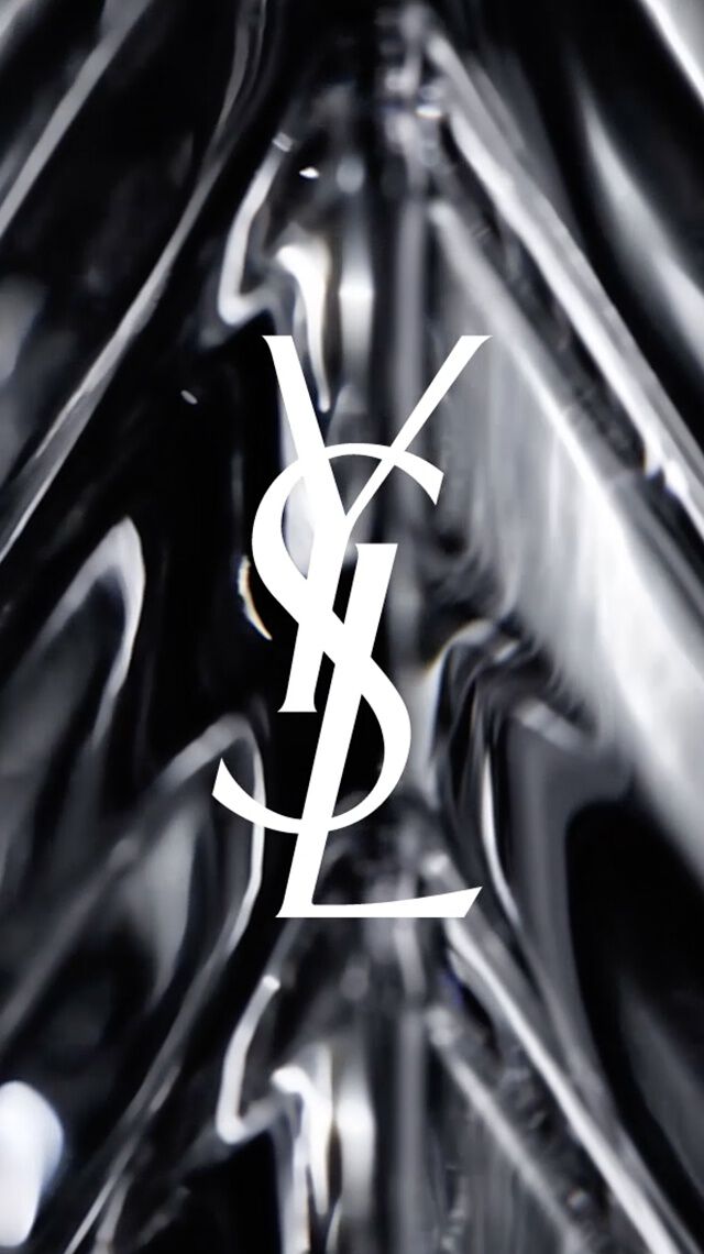 Logotipo blanco de YSL sobre un fondo de cristal facetado negro.