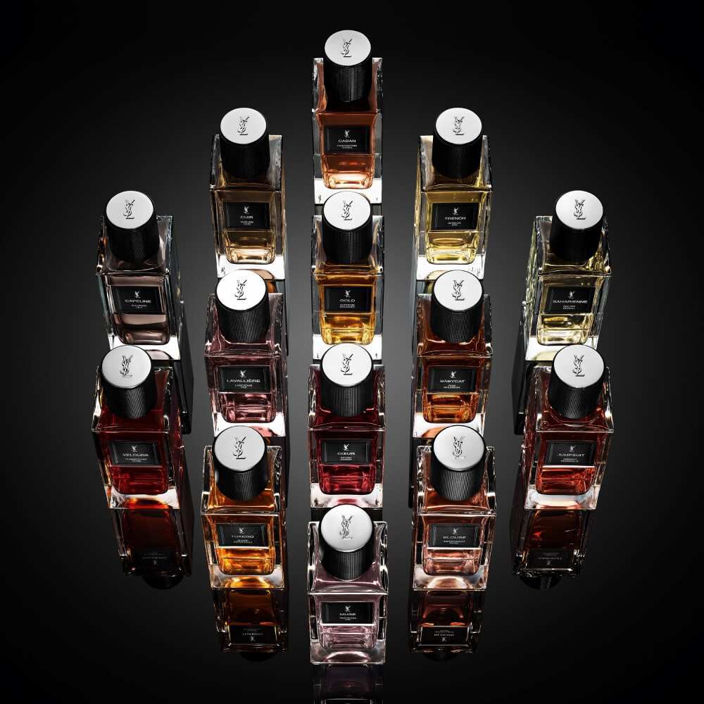Frascos de perfume YSL dispuestos en una composicion geometrica sobre fondo negro