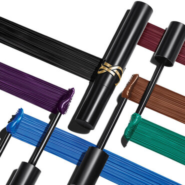 Presentacion de producto con un tubo de mascara negra rodeado de aplicadores y trazos en negro, burdeos, violeta, azul, verde y marron.