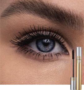 Close-up of an eye with long, defined lashes, featuring a deep blue iris. A tube of mascara is displayed beside the eye.