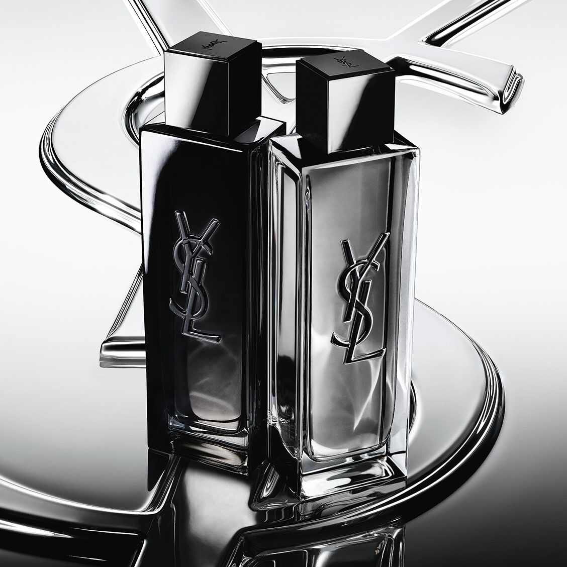 Dos frascos de perfume YSL en negro y plateado