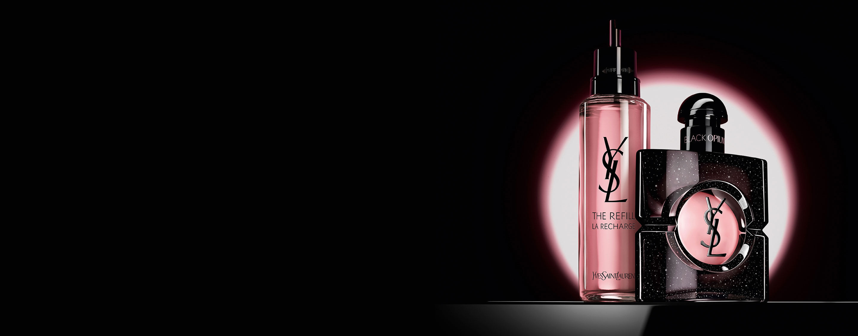 Frasco de Black Opium Eau de Parfum junto a su frasco de recarga de vidrio de 100 ml con el logotipo de YSL.
