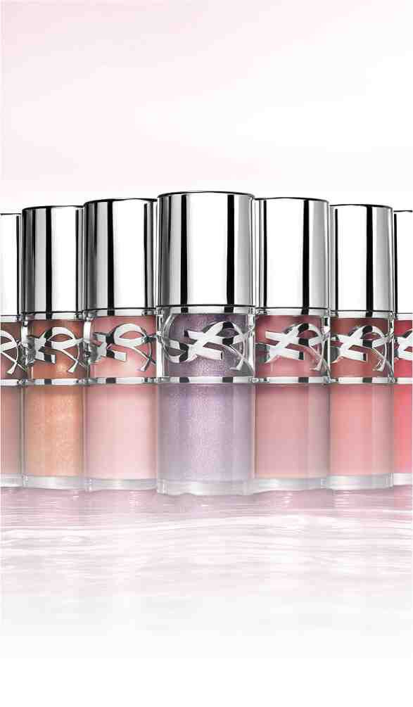 A lineup of various lip glosses displayed in sleek, silver-capped bottles, showcasing a range of colors from nude to pink.
