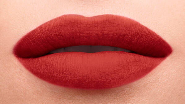 Close-up of beautifully defined lips coated in a rich, deep red lipstick, showcasing a smooth and matte finish.
