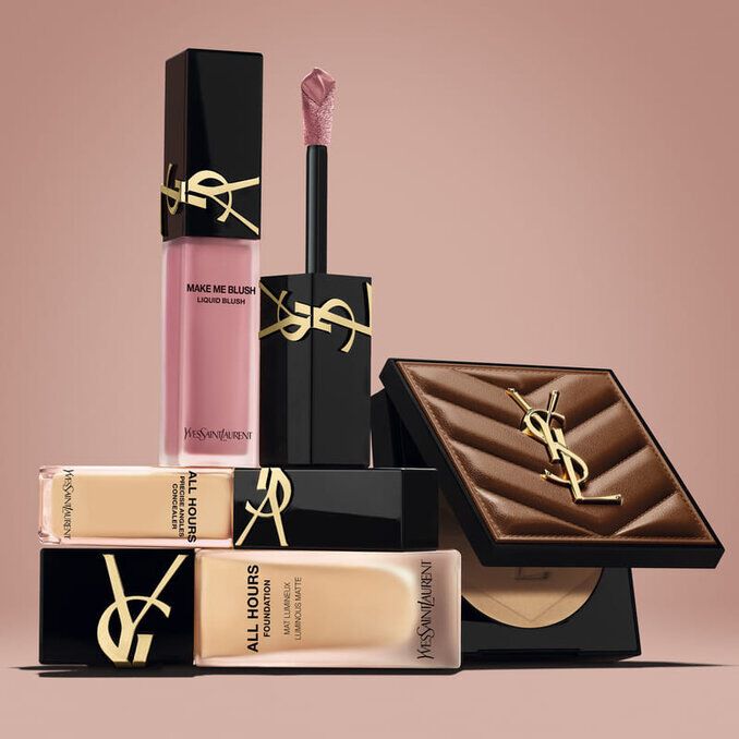 Productos de belleza de YSL, incluido un blush, una base de maquillaje y un polvo compacto, sobre fondo nude.