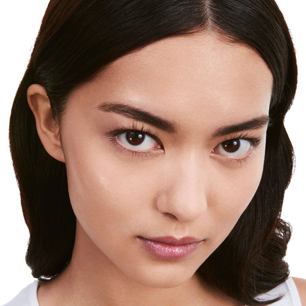 A close-up of a young woman with long dark hair and natural makeup, looking directly at the camera with a neutral expression.