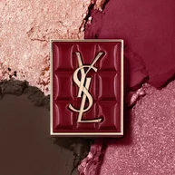 Paleta YSL Couture Mini Clutch sobre un fondo texturizado de sombras en polvo destellantes del #1982 Burgundy Millesime.