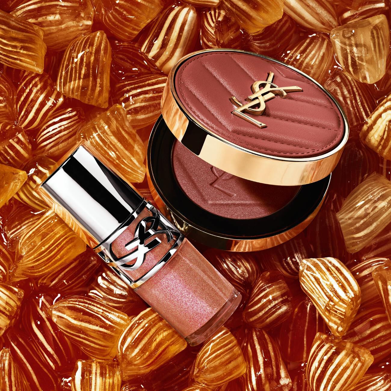 YSL LOVESHINE Plumping Lip Oil Gloss shade 10 and Make Me Blush shade 66, amidst vibrant pink heart-shaped sweets.