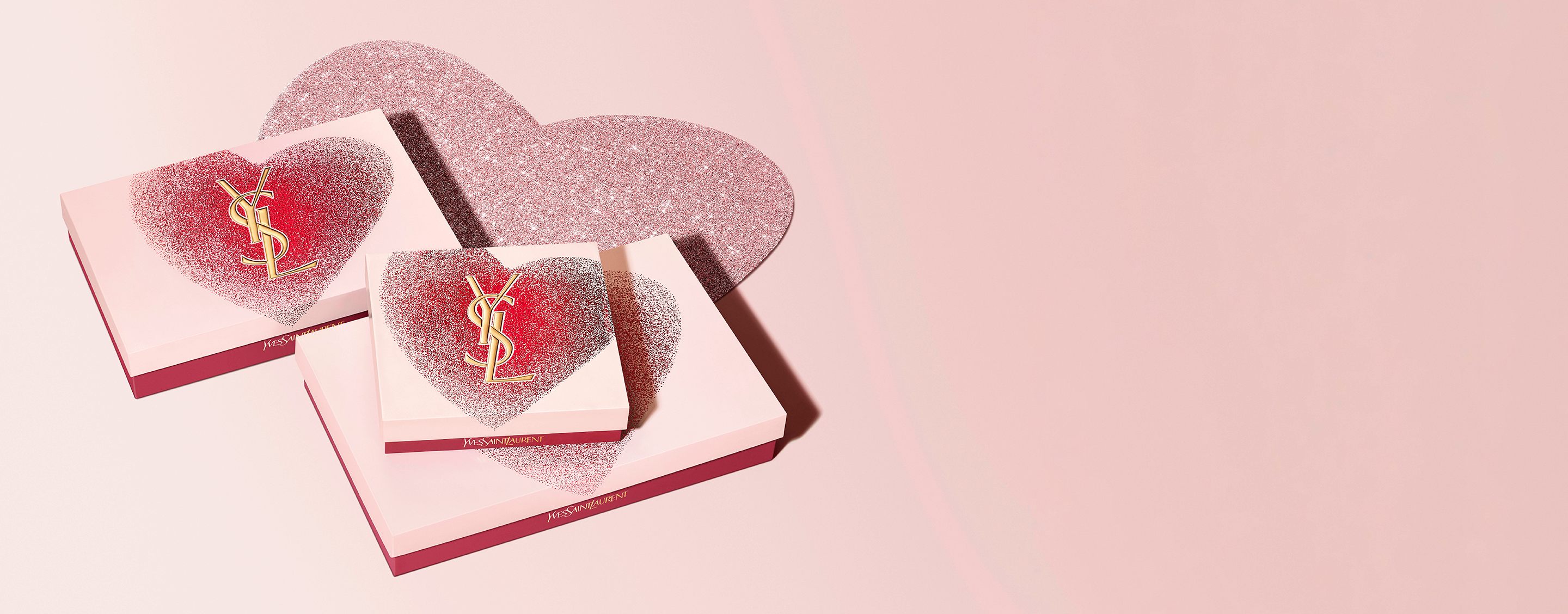 Sets de regalo de San Valentín de YSL Beauty en cajas con forma de corazón con el logotipo de YSL dorado, con un diseño brillante en rojo y rosa.