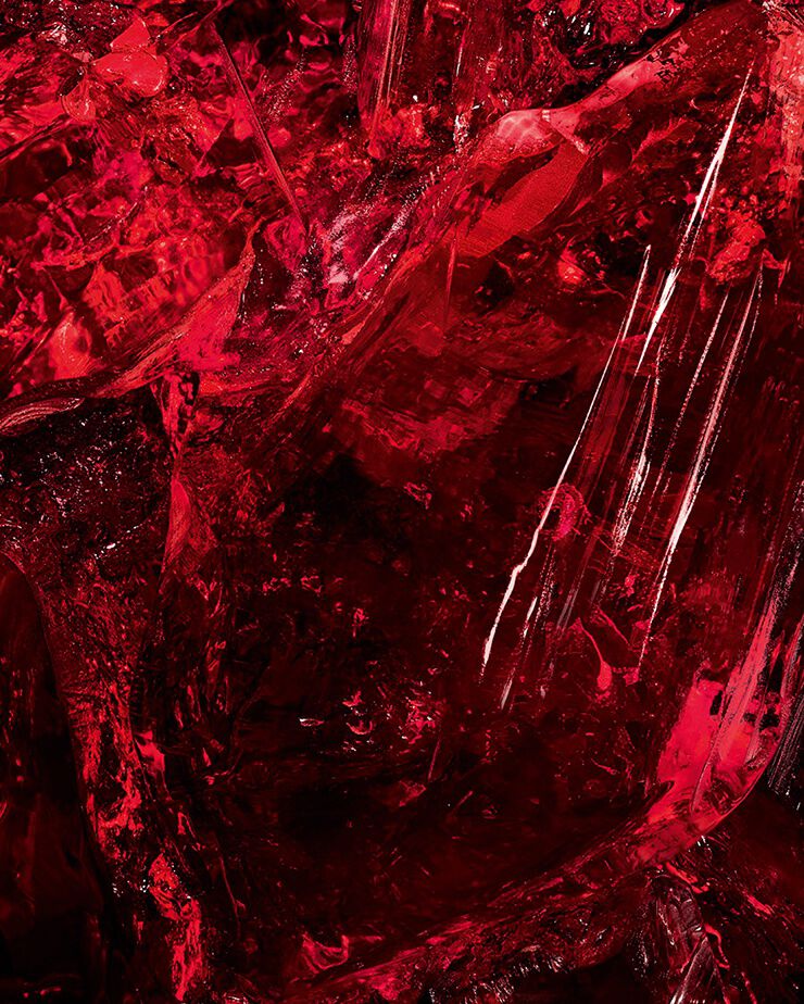 Toma macro de un cristal de ámbar rojo texturizado,
un ingrediente clave de CŒUR Eau
de Parfum de YSL, que muestra su
profundidad en bruto.