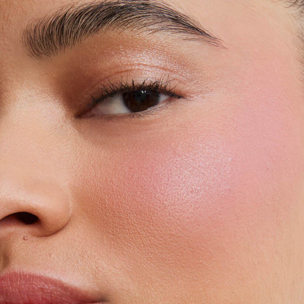 Primer plano de la mejilla de una modelo mostrando el acabado mate de enfoque suave y difuminado de Make Me Blush Powder en el tono #44, para un rubor de color intenso y modulable.