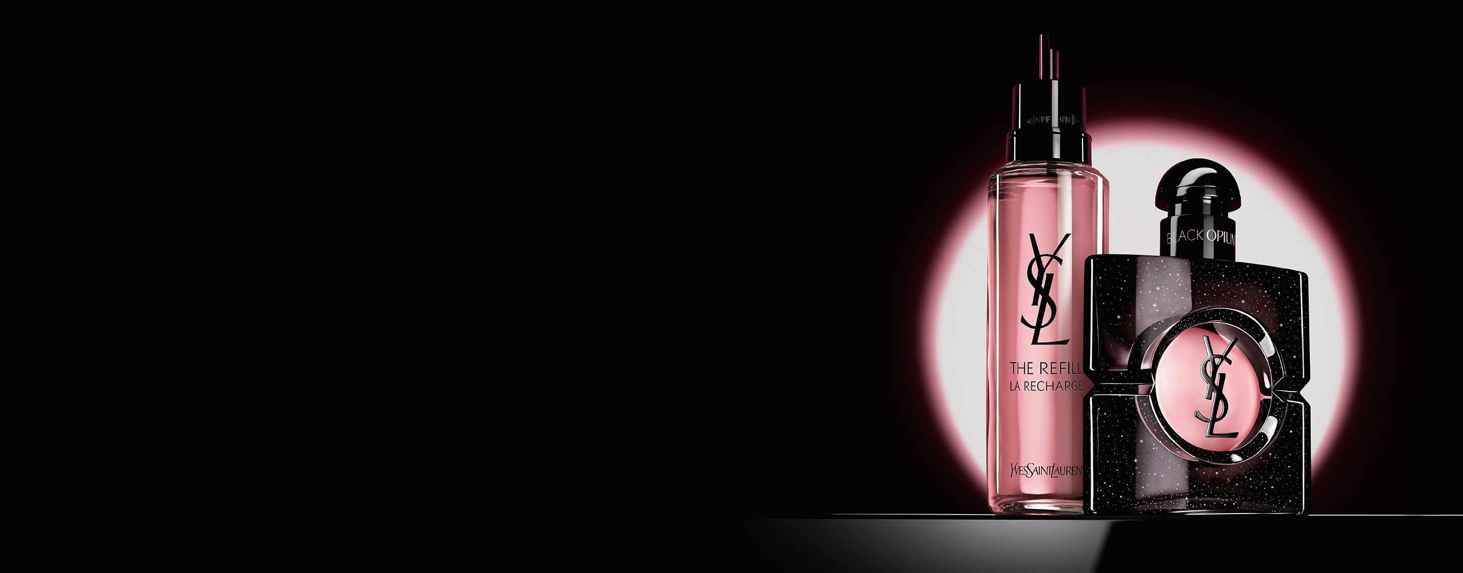 Frasco de Black Opium Eau de Parfum junto a su frasco de recarga de vidrio de 100 ml con el logotipo de YSL.