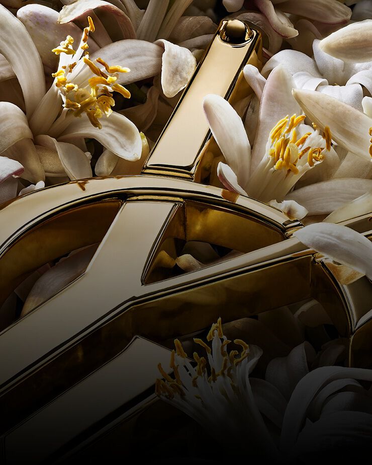 Cassandre dorado de YSL con flores blancas de azahar.
