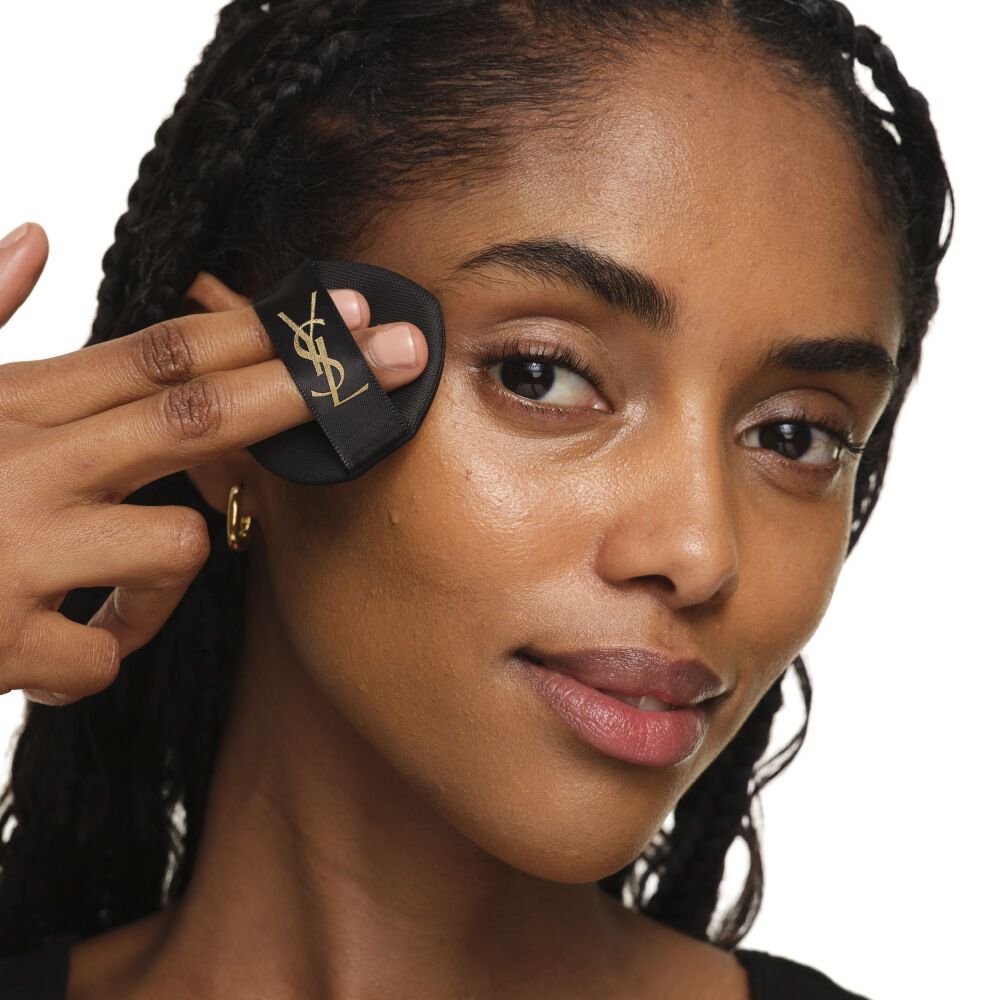 Primer plano que muestra cómo aplicar YSL SKIN AFFAIR CUSHION en la mejilla para una cobertura impecable, modulable y radiante.