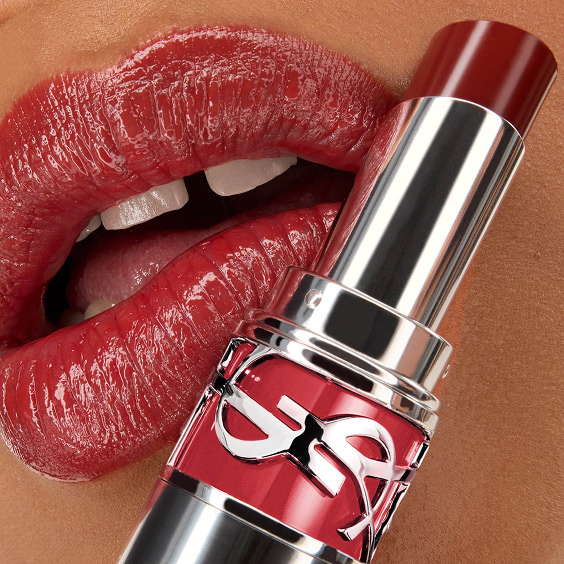 Primer plano de los labios de Mawena con la barra de labios YSL LOVESHINE en el tono 219 Berry Crush, con el envase del labial en primer plano.
