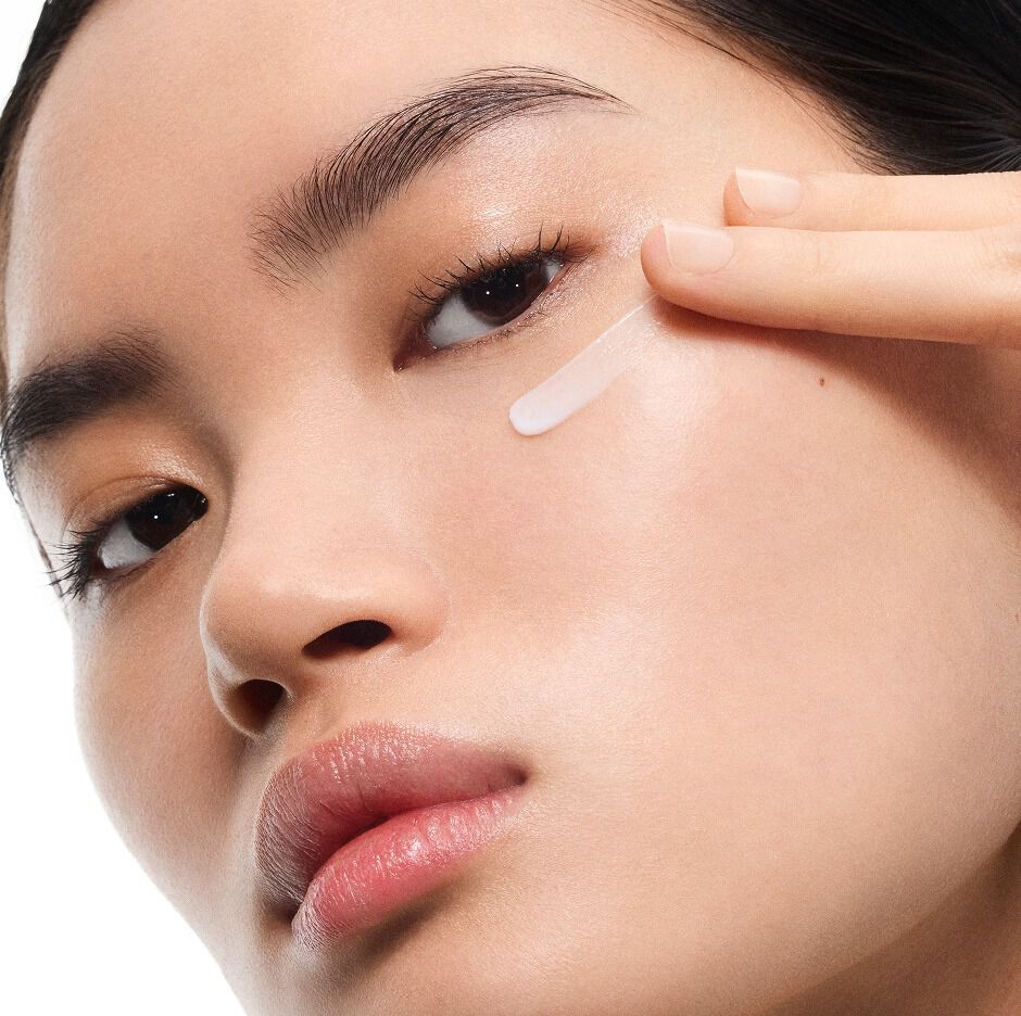 Mingma, modelo de piel clara, aplicando la crema Eye Reboot Pure Shots de YSL bajo su ojo, mostrando su delicada textura.