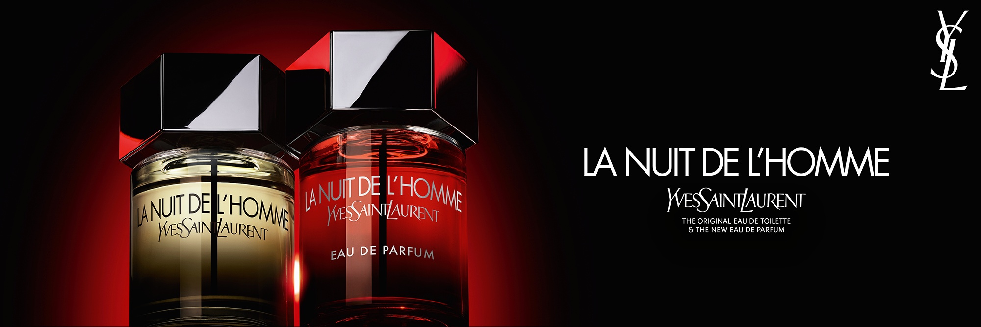 Una toma dramática de los frascos de La Nuit de l’Homme Eau de Toilette y Eau de Parfum uno al lado del otro, contrastando el clásico líquido ámbar con el nuevo e intenso degradado rojo.