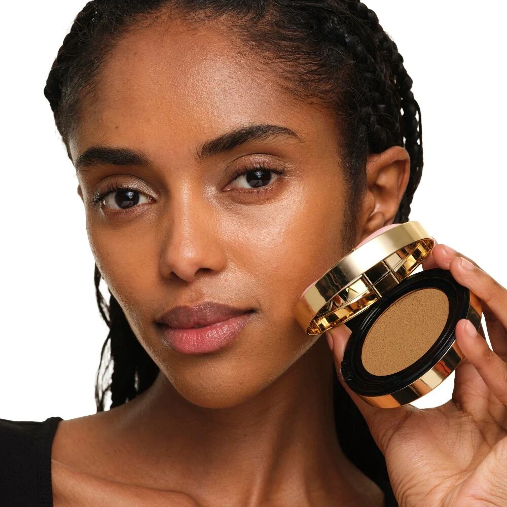 Modelo con piel media sosteniendo YSL SKIN AFFAIR SOFT GLOW CUSHION. Tez radiante, unificada y de aspecto natural.