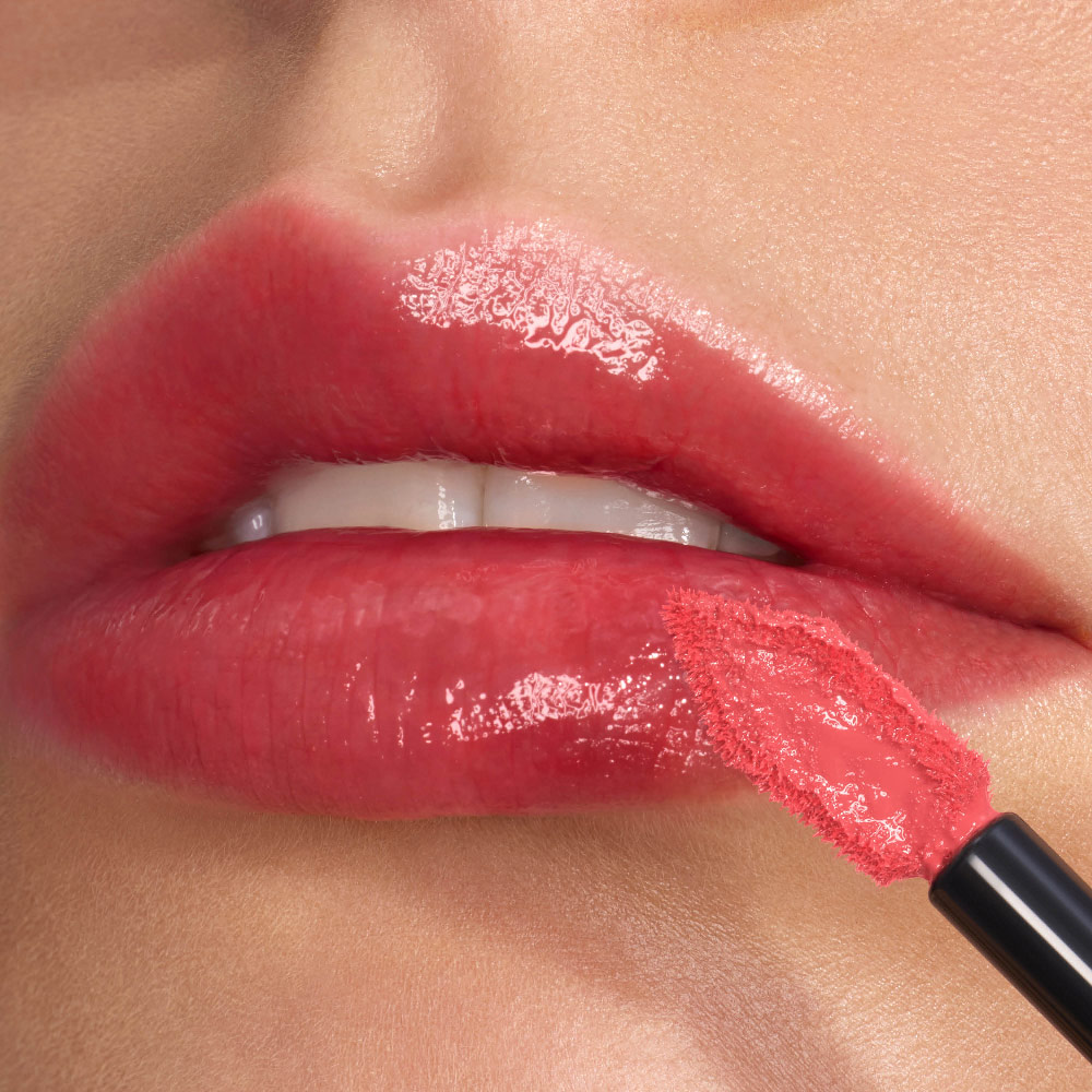 Primer plano de unos labios brillantes y de alto brillo perfilados con precisión con el aplicador biselado y de punta plana de YSL.