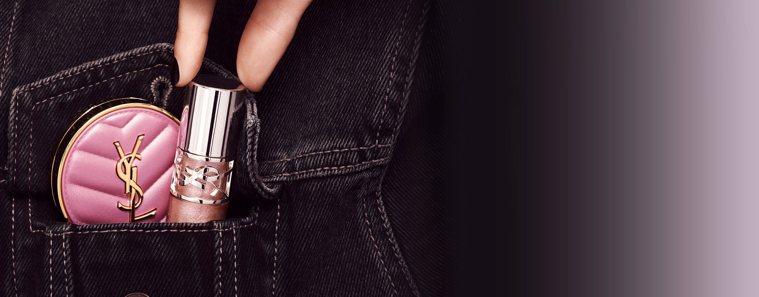 Mano colocando el brillo de labios YSL LOVESHINE y el rubor rosa Make Me Blush en un bolsillo vaquero