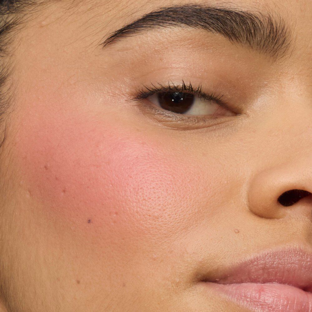 Primer plano de la mejilla de una modelo mostrando el acabado ultracremoso de YSL Make Me Blush Lifted Glow Cream Blush en el tono #44 Nude Lavallière, para un brillo vibrante y modulable con efecto lifting.