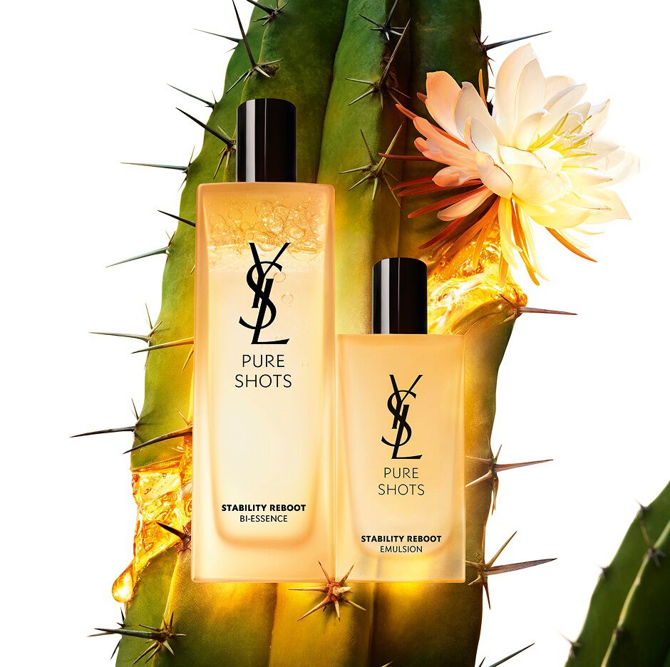 Productos YSL Pure Shots Stability Reboot Bi-Essence y Stability Reboot Emulsion delante de un cactus moonlight en flor