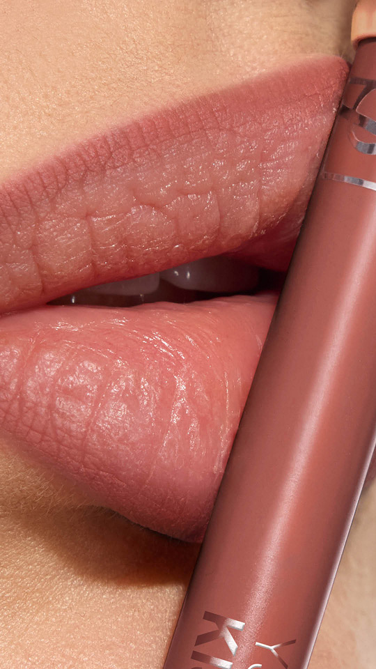 Primer plano vertical de unos labios con labial mate malva y su perfilador YSL a juego.