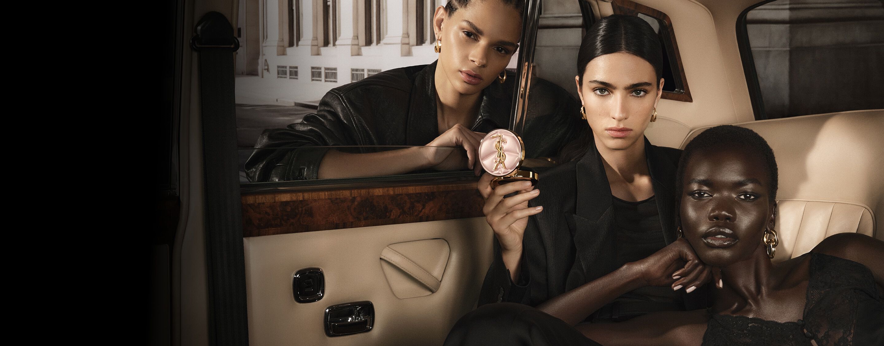 Tres modelos en un taxi con YSL SKIN AFFAIR CUSHION. Tonos de piel diversos y complejos radiantes de alta costura.